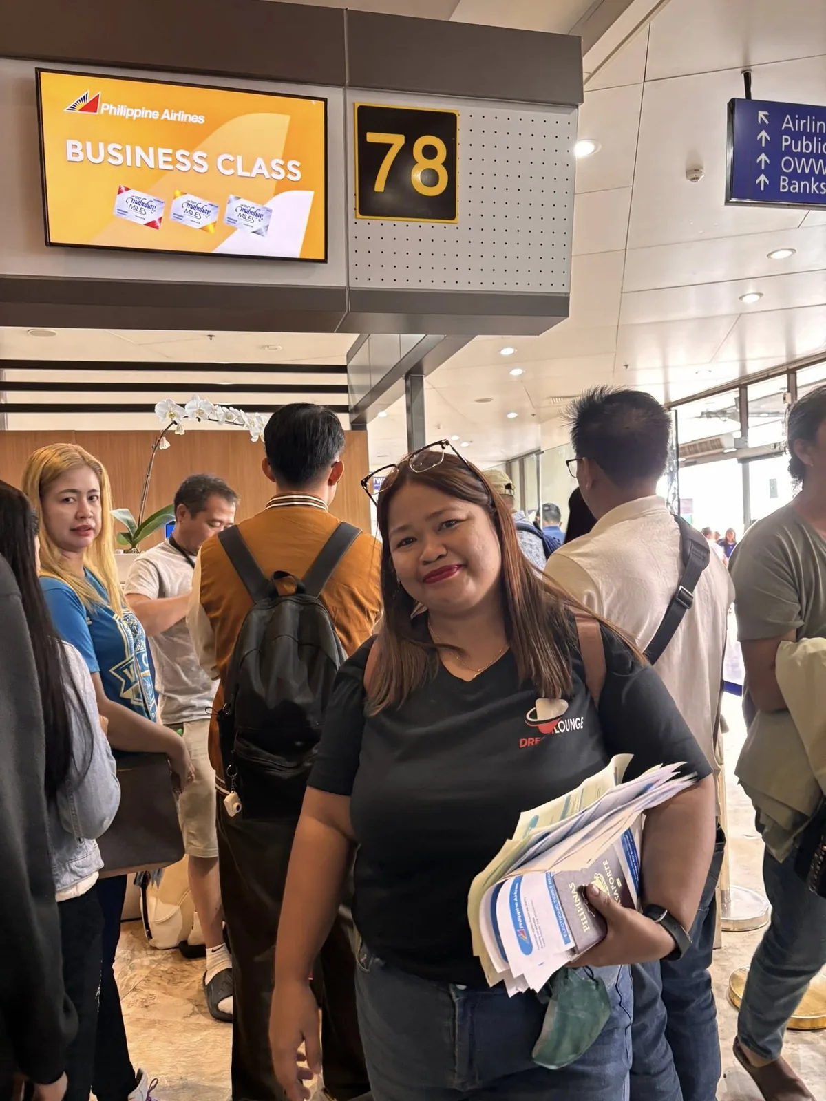 Dream Lounge representative assisting travelers at an airline check-in counter